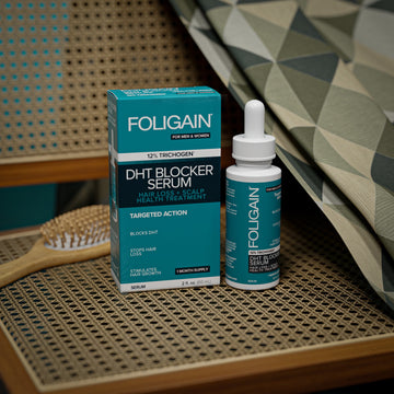 엮어서 만든 의자 좌판 위에 놓인 FOLIGAIN DHT 차단 세럼 병과 상자.