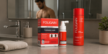 욕실 카운터 위에 놓인 FOLIGAIN 남성용 TRIOXIDIL 외용 트리트먼트와 샴푸.
