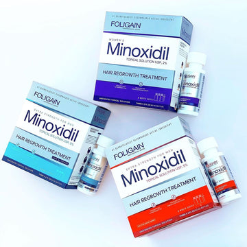 주황색, 파란색, 보라색 포장의 FOLIGAIN 미녹시딜 상자와 병.